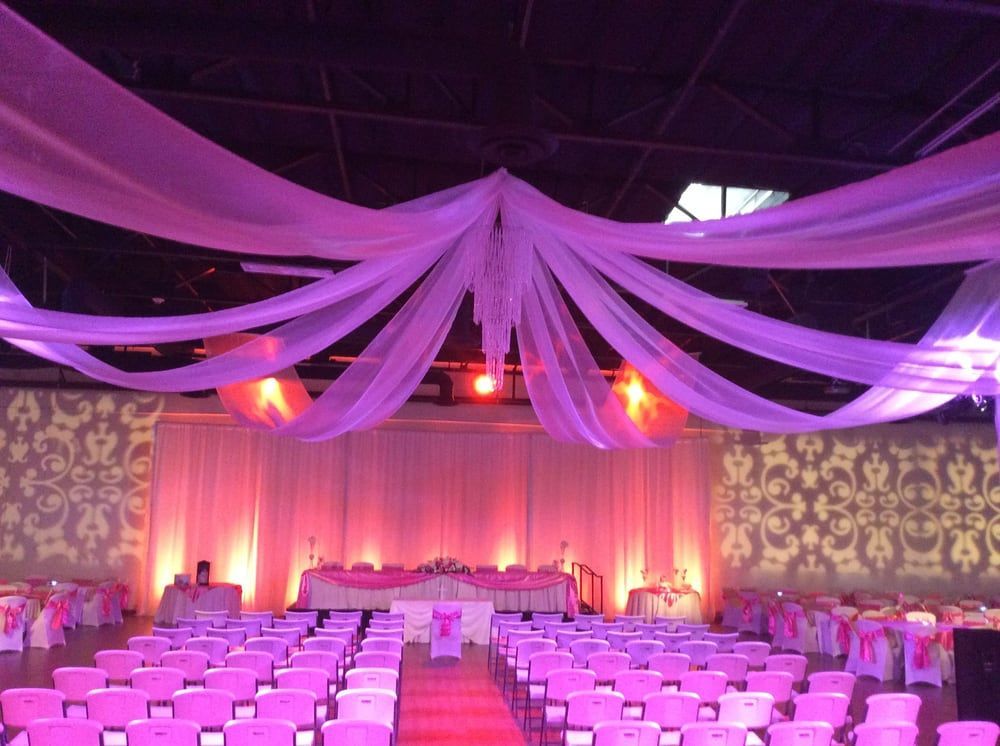 Rows of pink chairs are arranged for a wedding ceremony