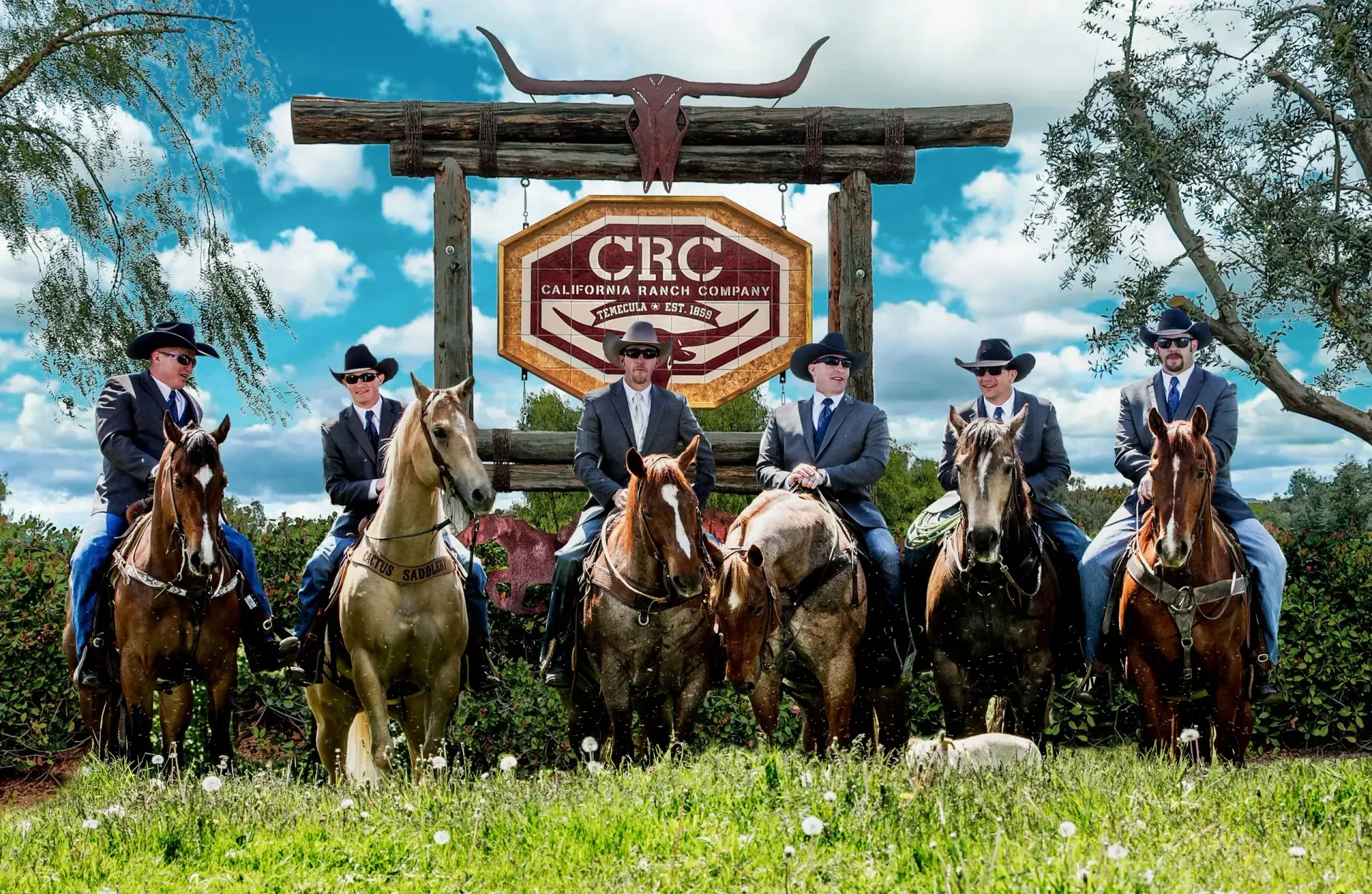 A group of men are riding horses in front of a sign that says crc.