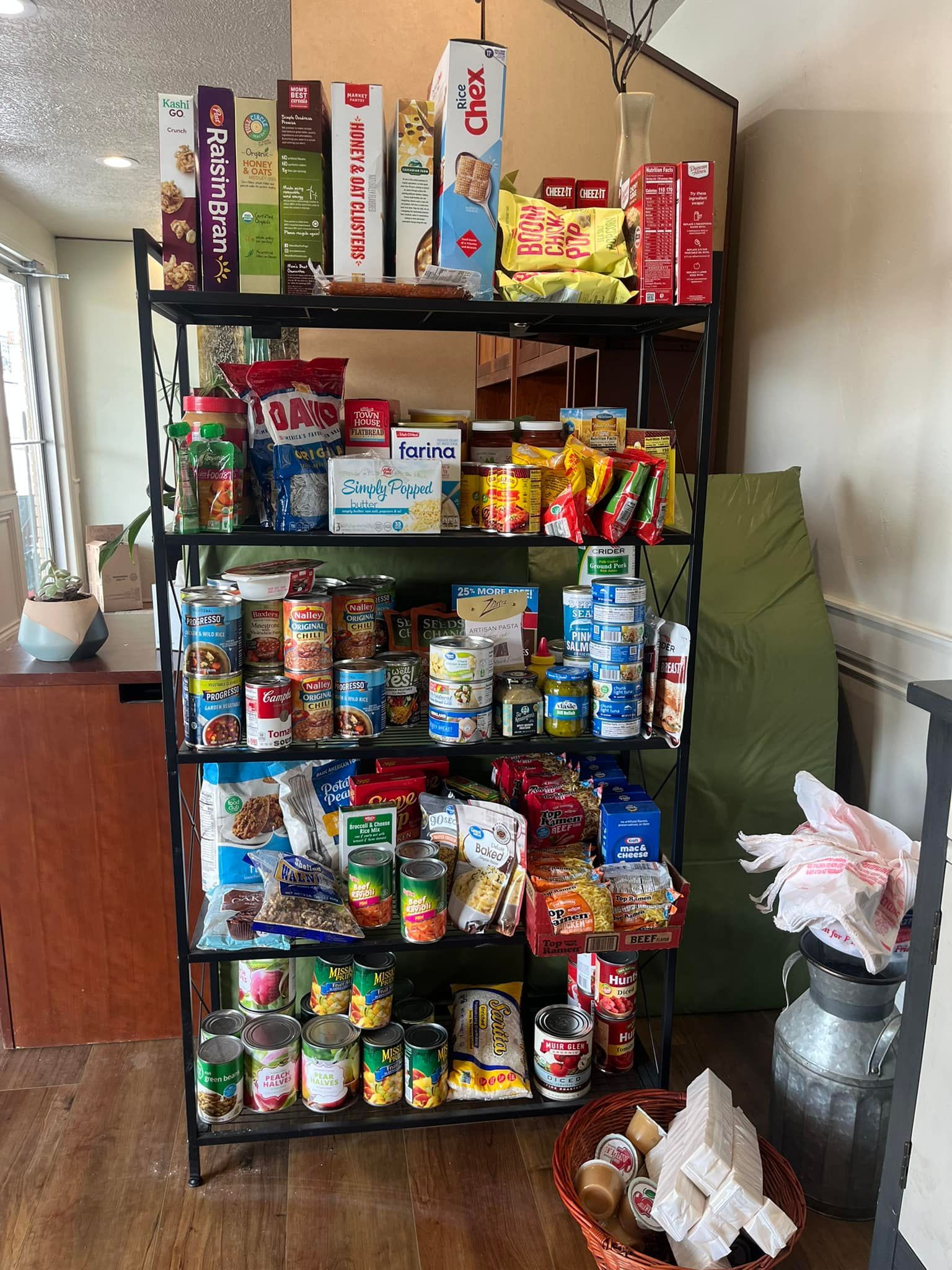 A shelf filled with lots of canned food and snacks.