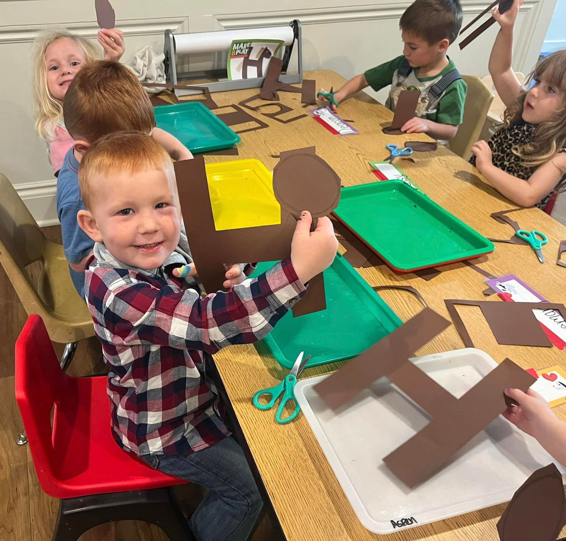 A group of children are sitting at a table making crafts