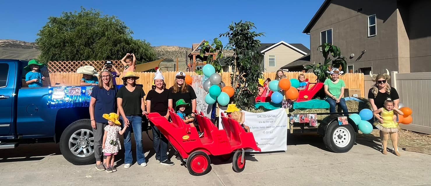 A group of people are standing in front of a blue truck.