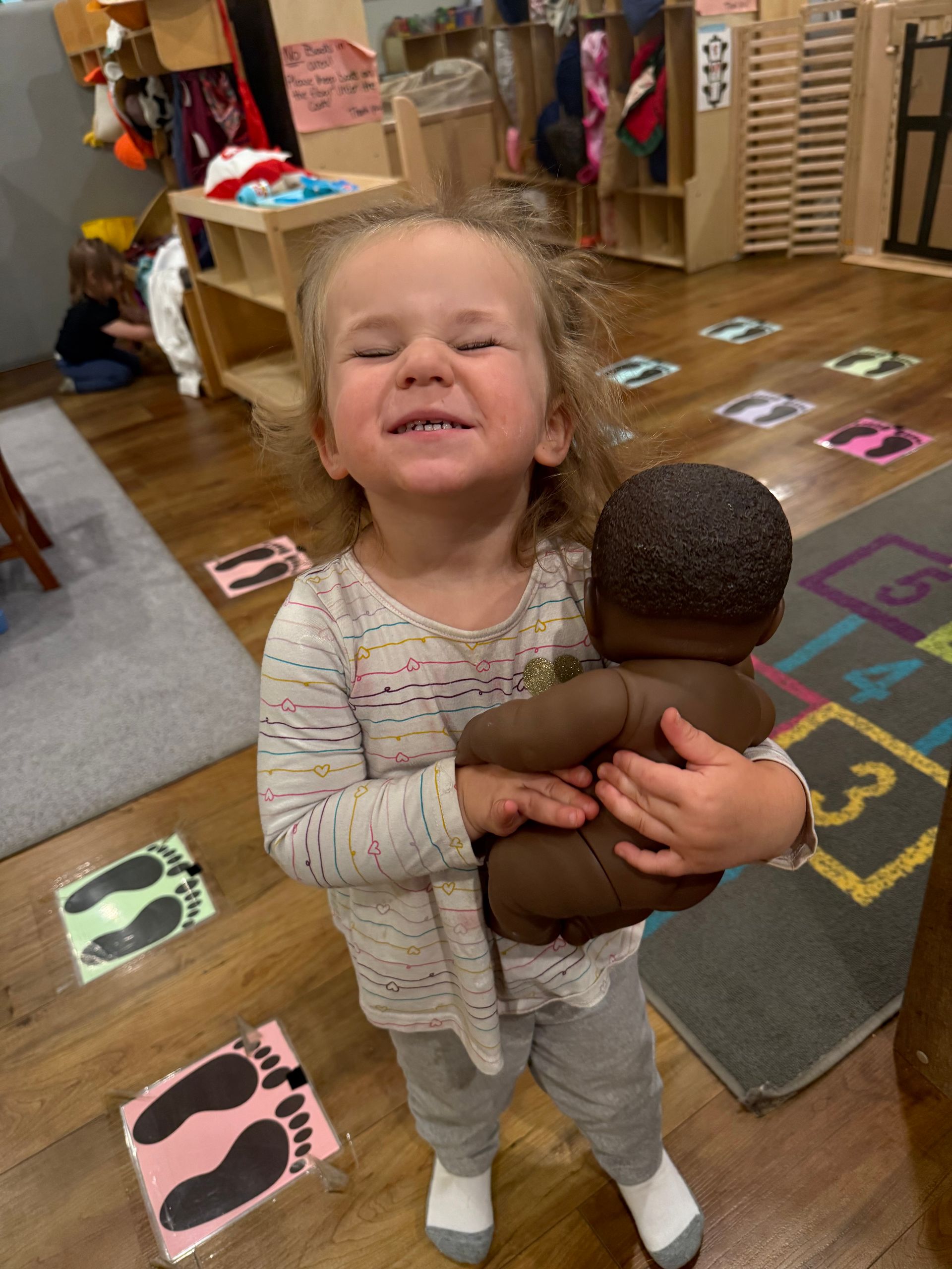 A group of young children are sitting at a table painting.