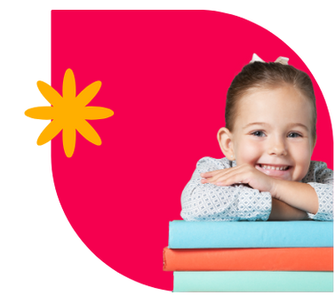 A little girl is sitting on a stack of books and smiling.