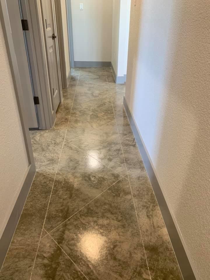 Narrow hallway with gray marble-look flooring and white walls, two doors on the left.