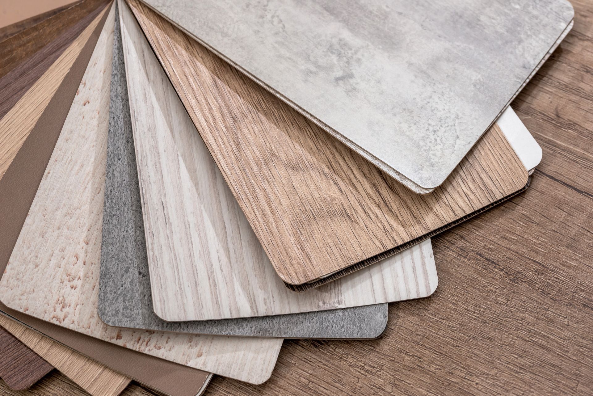 Color swatches of various wood and stone textures, fanned out on a wooden surface.