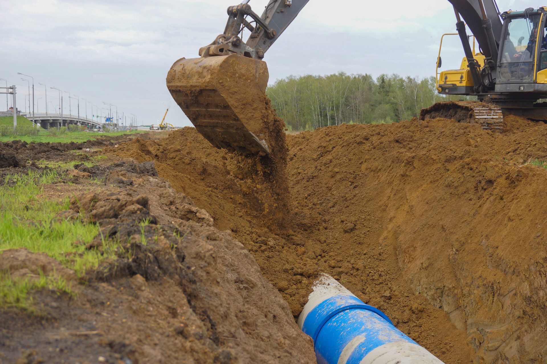 a yellow bulldozer is driving through a dirt field