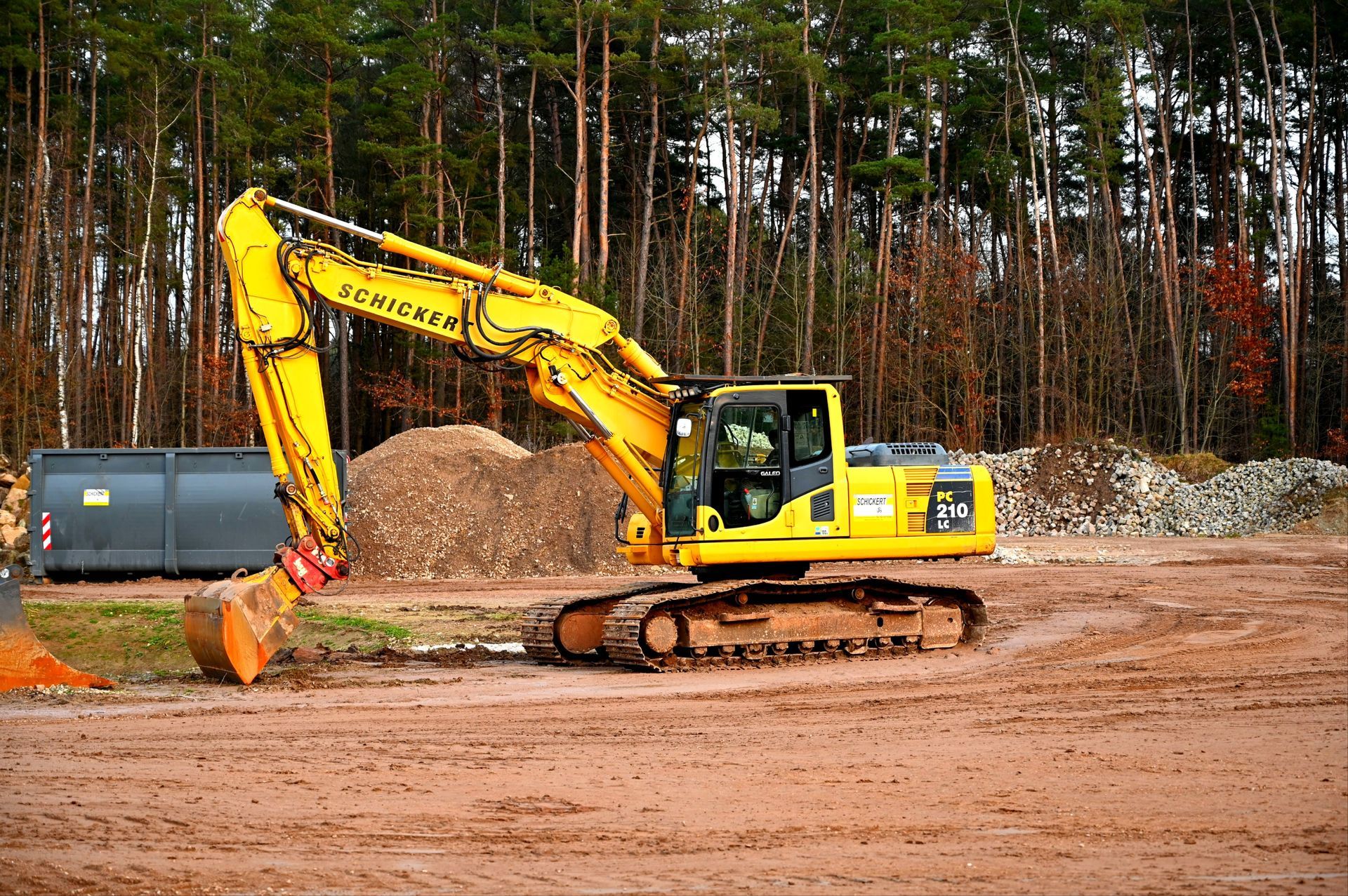 a yellow excavator with the word schicker on it