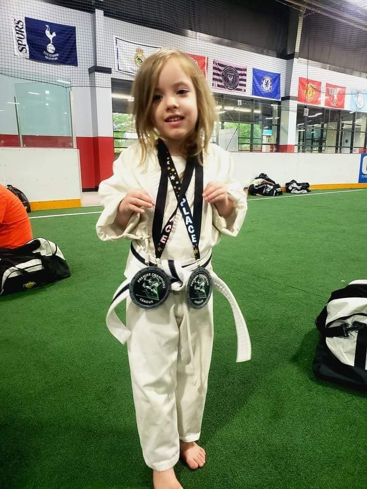 A person is holding a sparkler in their hand in the dark.