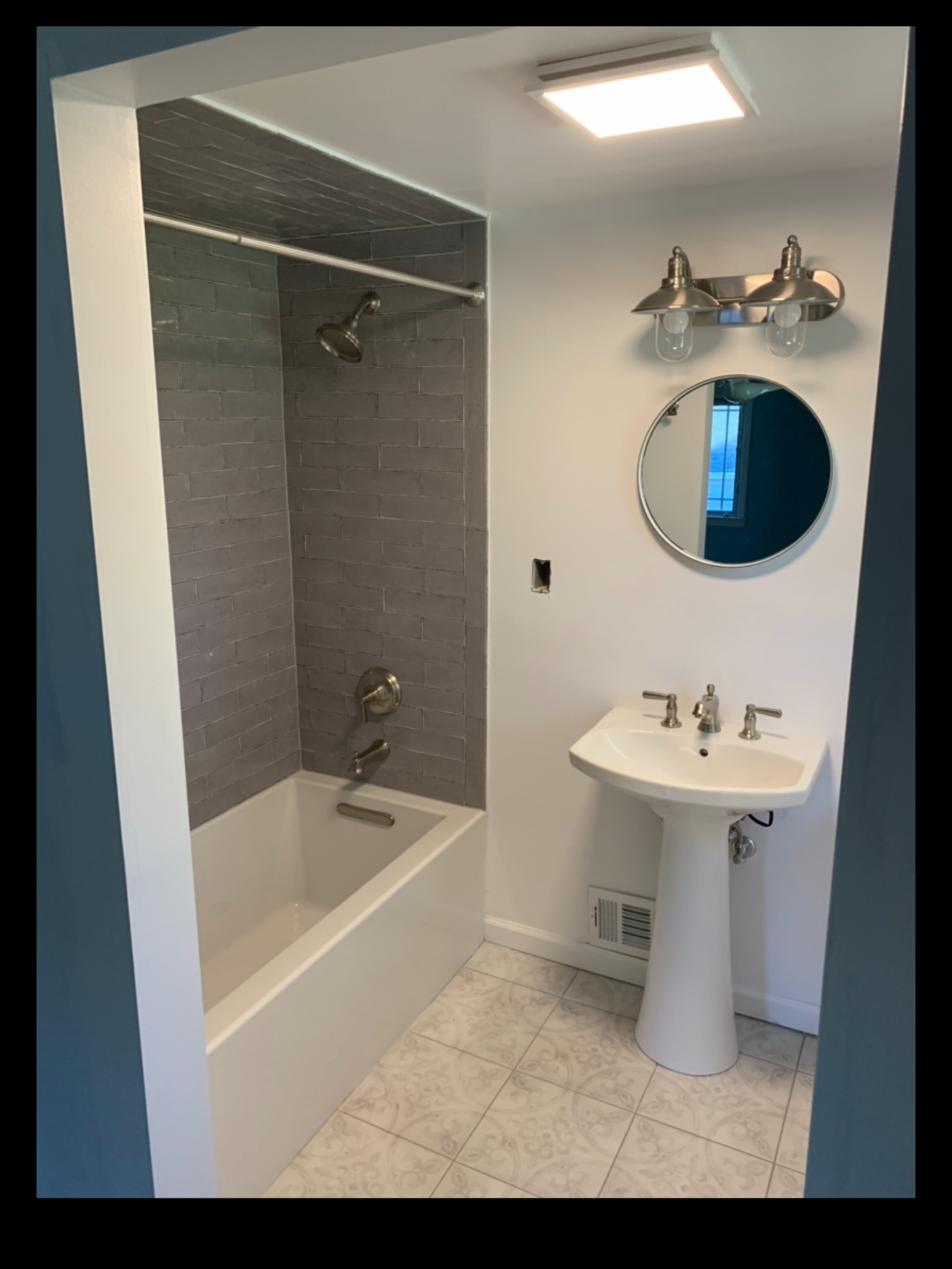 A bathroom with a sink a bathtub and a mirror