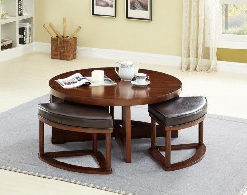 A round coffee table with stools underneath it in a living room