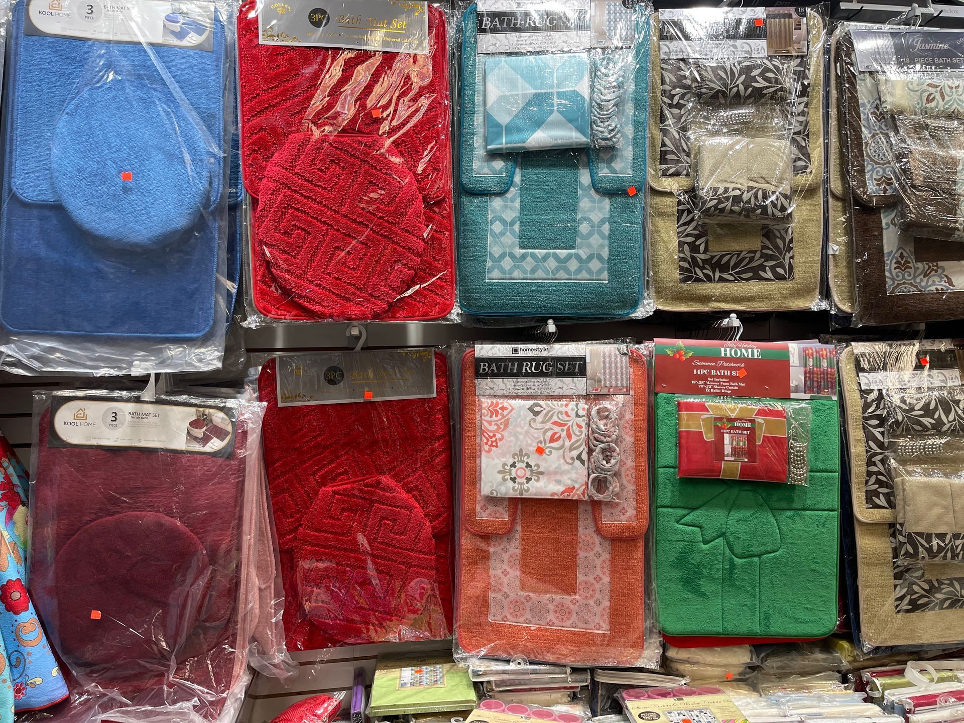 A variety of bath mats are displayed on a wall in a store.