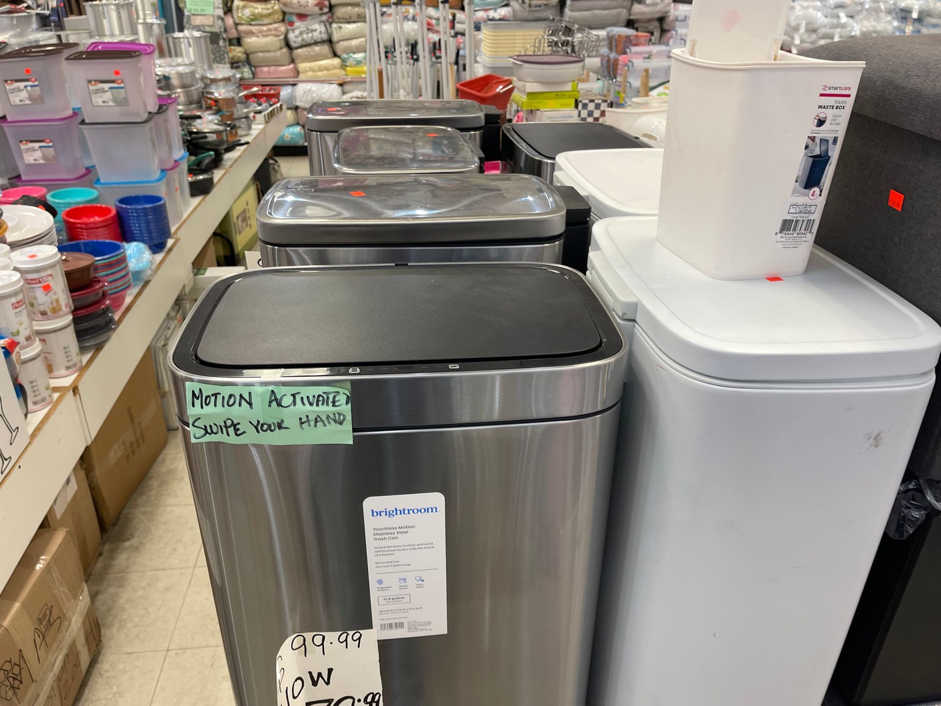 A row of stainless steel trash cans in a store.