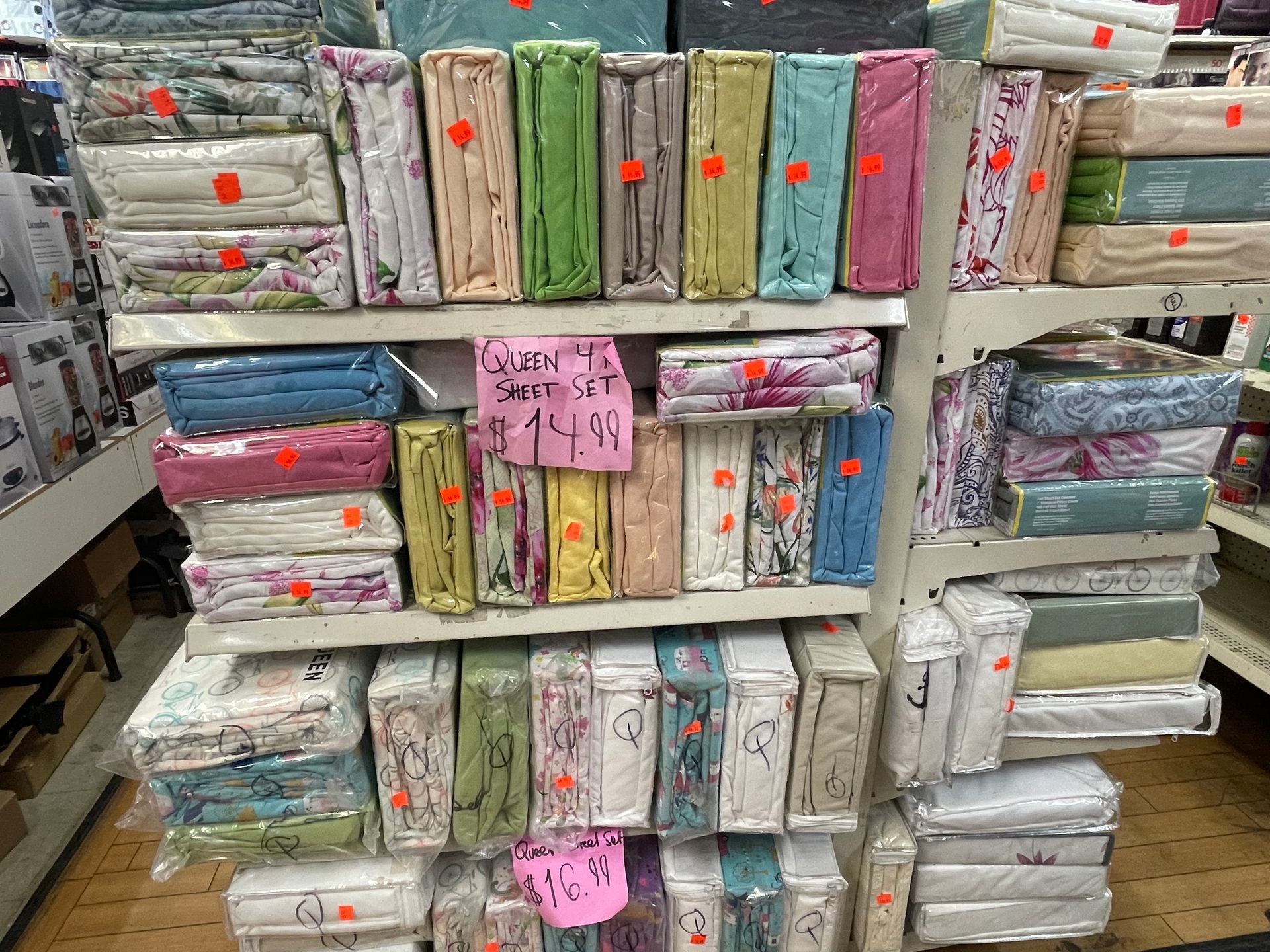 A store shelf filled with lots of sheets and blankets for sale.