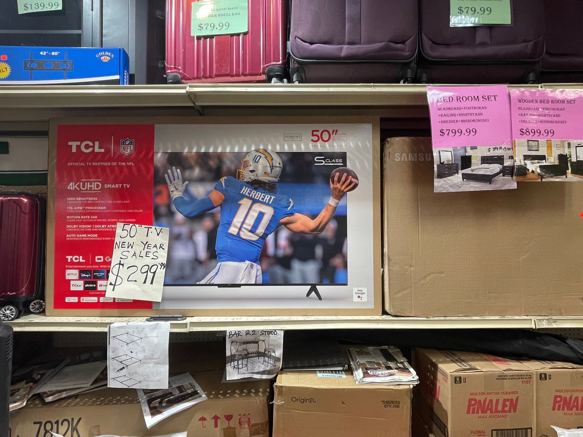 A tcl television is sitting on a shelf in a store.