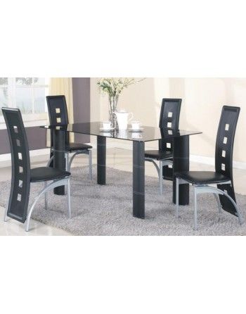 A dining room table with four black chairs and a vase of flowers on it.