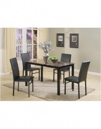 A dining room table with four black chairs and a vase of apples on it.