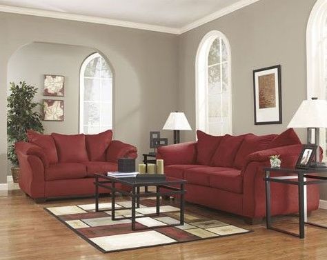A living room with two red couches and a rug