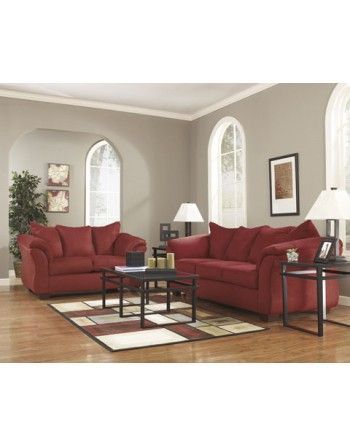 A living room with red furniture and a rug.