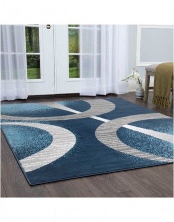 A blue and gray rug is sitting on a wooden floor in a living room.
