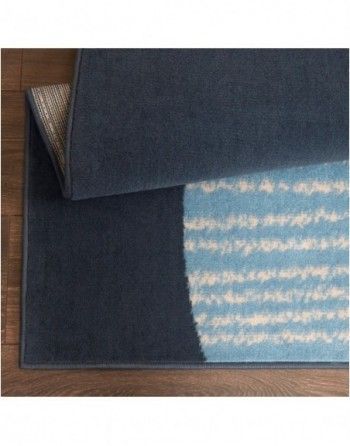 A blue and white rug is laying on a wooden floor.