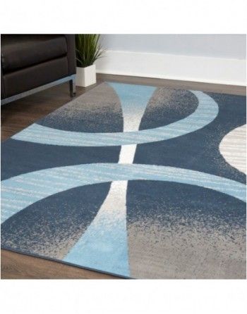 A blue and gray rug is sitting on a wooden floor in a living room.