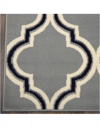 A gray rug with a black and white pattern on it