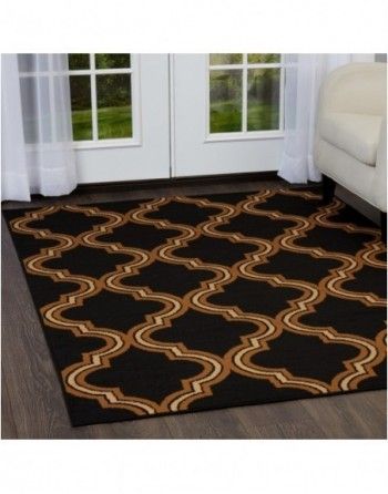 A black and brown rug in a living room next to a couch