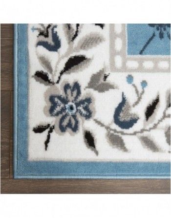 A blue and white rug with flowers and leaves on it
