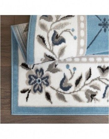 A blue and white rug with flowers and leaves on it