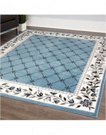 A blue and white rug is sitting on a wooden floor in a living room.