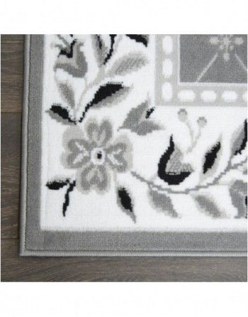 A white and gray rug with flowers and leaves on it