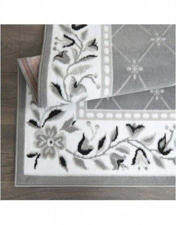 A gray and white rug with flowers and leaves on it