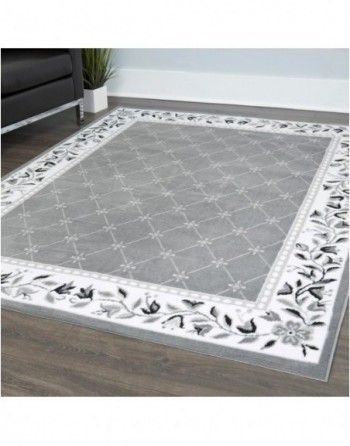 A gray and white rug is sitting on a wooden floor in a living room.