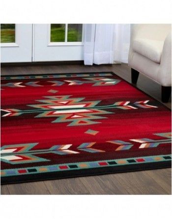 A red rug is in a living room next to a chair