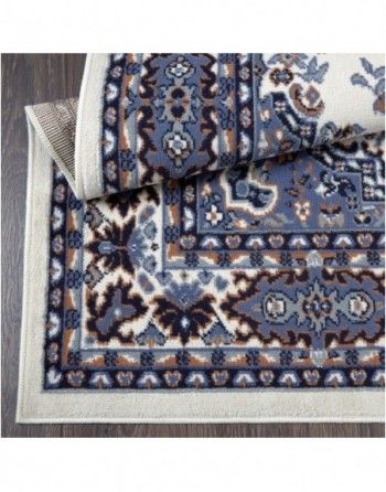 A rug with a floral pattern is rolled up on a wooden floor.