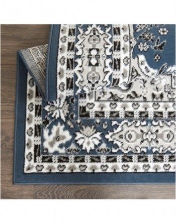 A blue and white rug is sitting on top of a wooden floor.