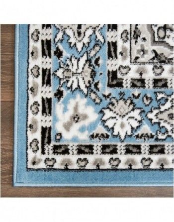 A blue and white rug with a floral pattern on it