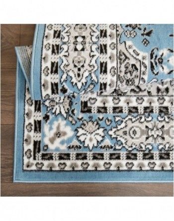 A blue and white rug is sitting on a wooden floor.