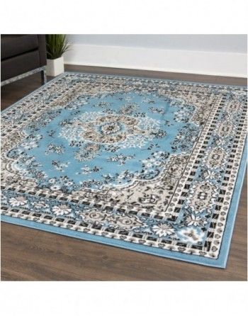 A blue rug is sitting on a wooden floor in a living room.