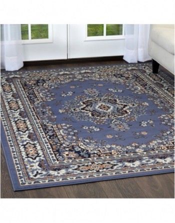 A blue rug is sitting on a wooden floor in a living room.