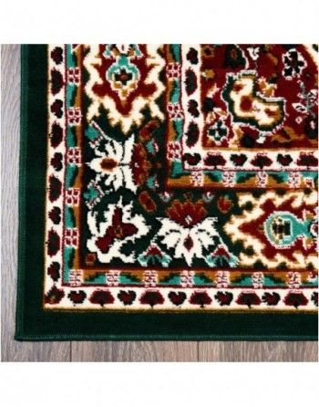 A green rug with a floral pattern on it