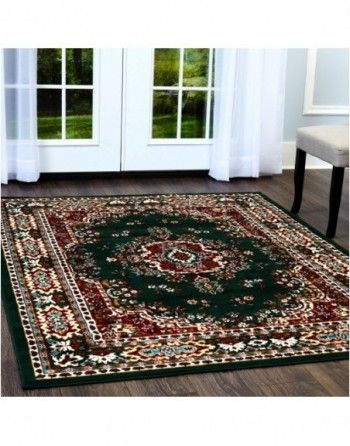 A green rug is sitting on a wooden floor in a living room.