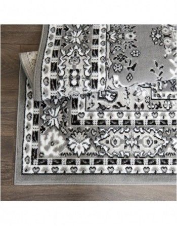 A black and white rug is sitting on top of a wooden floor.