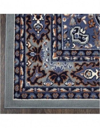 A blue and brown rug with a wooden border is on a wooden floor.