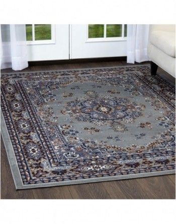 A rug is sitting on a wooden floor in a living room next to a couch.