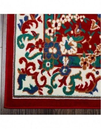 A rug with a red border and flowers on it