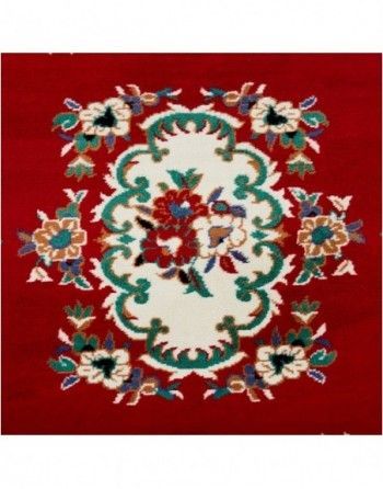 A red rug with white and green flowers on it
