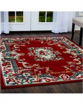 A red rug is sitting on a wooden floor in front of a window