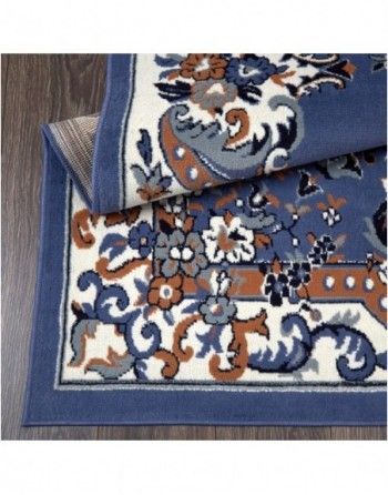 A blue and white rug with flowers on it is on a wooden floor.