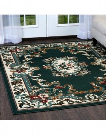 A green rug is sitting on a wooden floor in a living room.